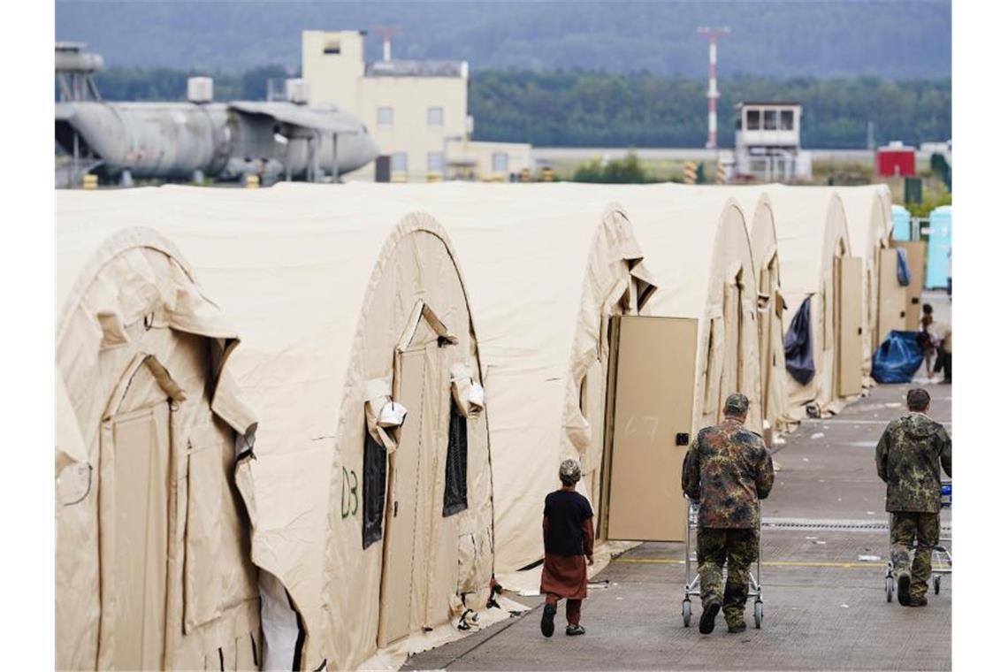 Zeltstadt: Afghanen warten in Ramstein auf Weiterreise US-Soldaten gehen auf der Ramstein Air Base mit Einkaufswagen an einer Reihe von Zelten vorbei. Foto: Uwe Anspach/dpa
