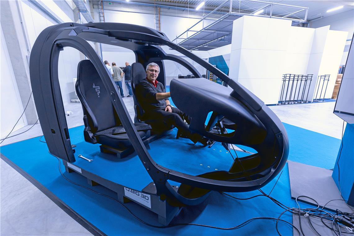 Vertriebsleiter Oliver Friz hat auf dem Pilotensitz eines Helikoptersimulators Platz genommen. Das Cockpit besteht aus 14 Kunststoffteilen, die alle aus dem 3-D-Drucker der Backnanger Firma Q.Big 3D stammen.Fotos: Alexander Becher (2), K. Fritz