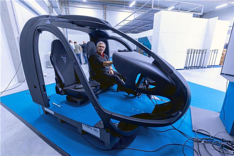 Vertriebsleiter Oliver Friz hat auf dem Pilotensitz eines Helikoptersimulators Platz genommen. Das Cockpit besteht aus 14 Kunststoffteilen, die alle aus dem 3-D-Drucker der Backnanger Firma Q.Big 3D stammen.Fotos: Alexander Becher (2), K. Fritz