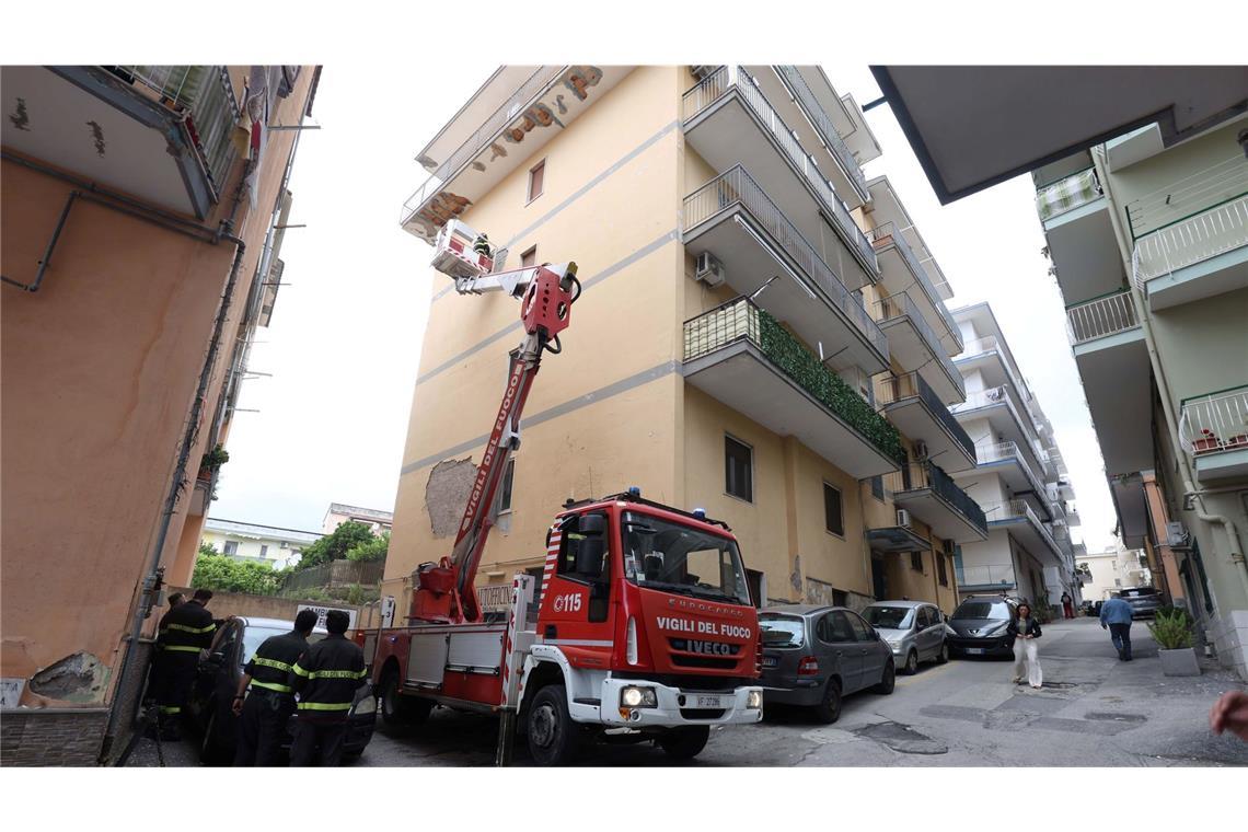 Von einem Hubwagen aus inspiziert ein Feuerwehrmann Schäden an einem Gebäude.