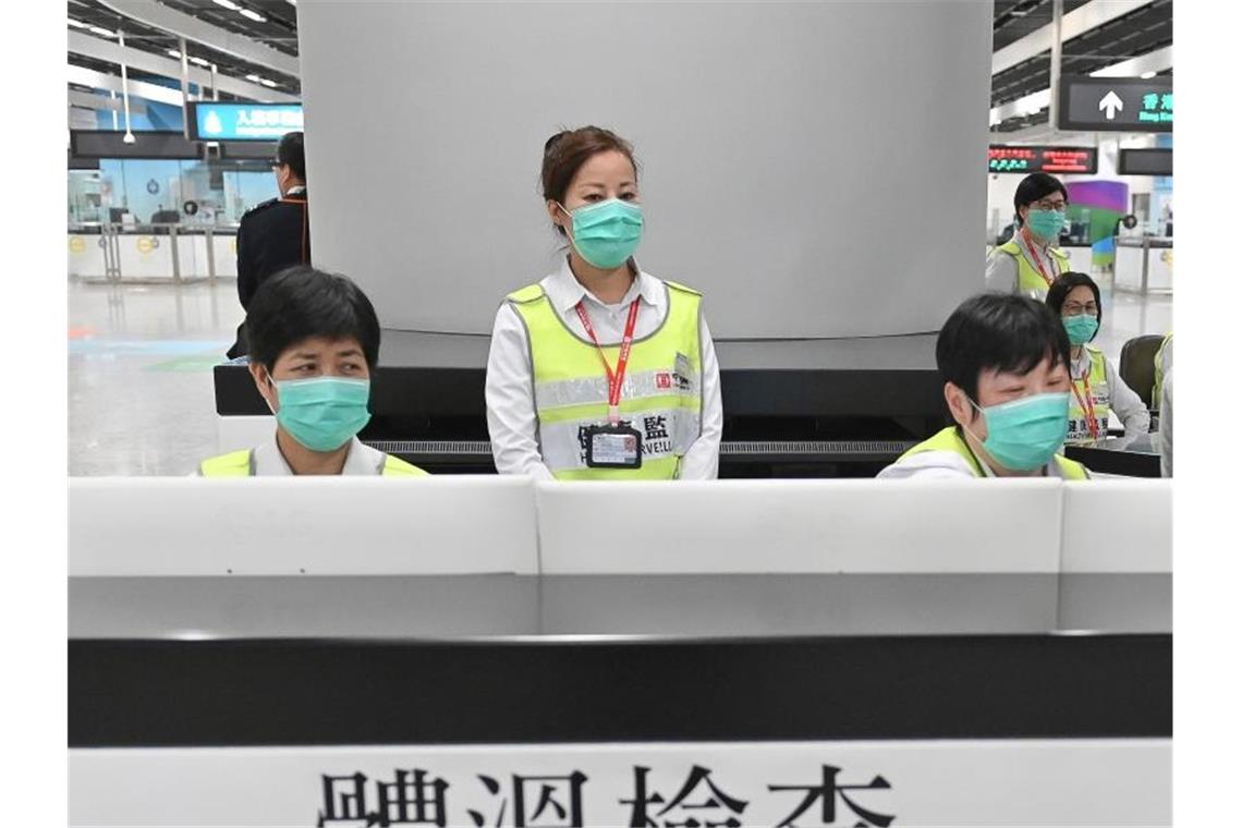 WHO beobachtet mysteriöse Lungenkrankheit in China Vorsorge in Hongkong: Mitarbeiter des Gesundheitswesens untersuchen am Bahnhof West Kowloon Station Reisende auf ihren Gesundheitszustand. Foto: Informationsdienst der Hongkonger Regierung/AP/dpa
