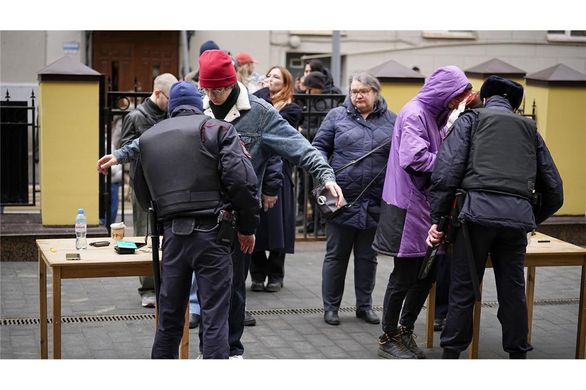 Wähler stehen am Sonntag um 12 Uhr  in Moskau  Schlange, um von der Polizei kontrolliert zu werden. Die russische Opposition hatte zu Protesten aufgerufen.