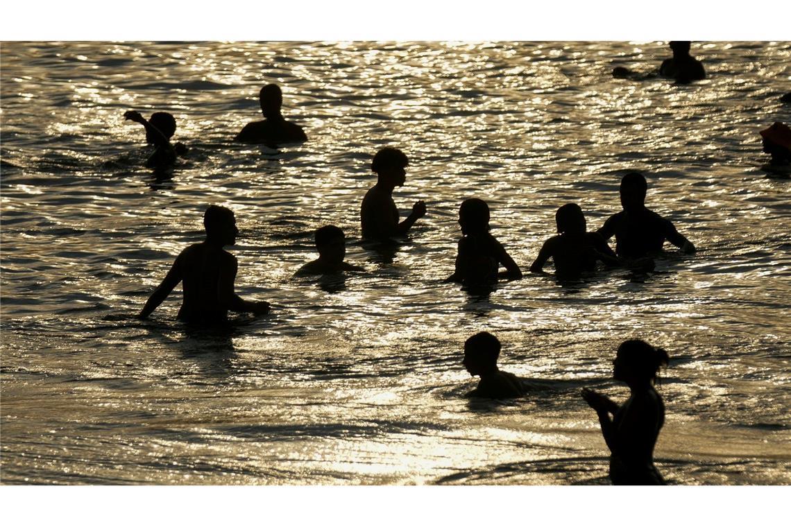 Während einer Hitzewelle tummeln sich Menschen im seichten Wasser des Strandes von Arpoador in Rio de Janeiro.