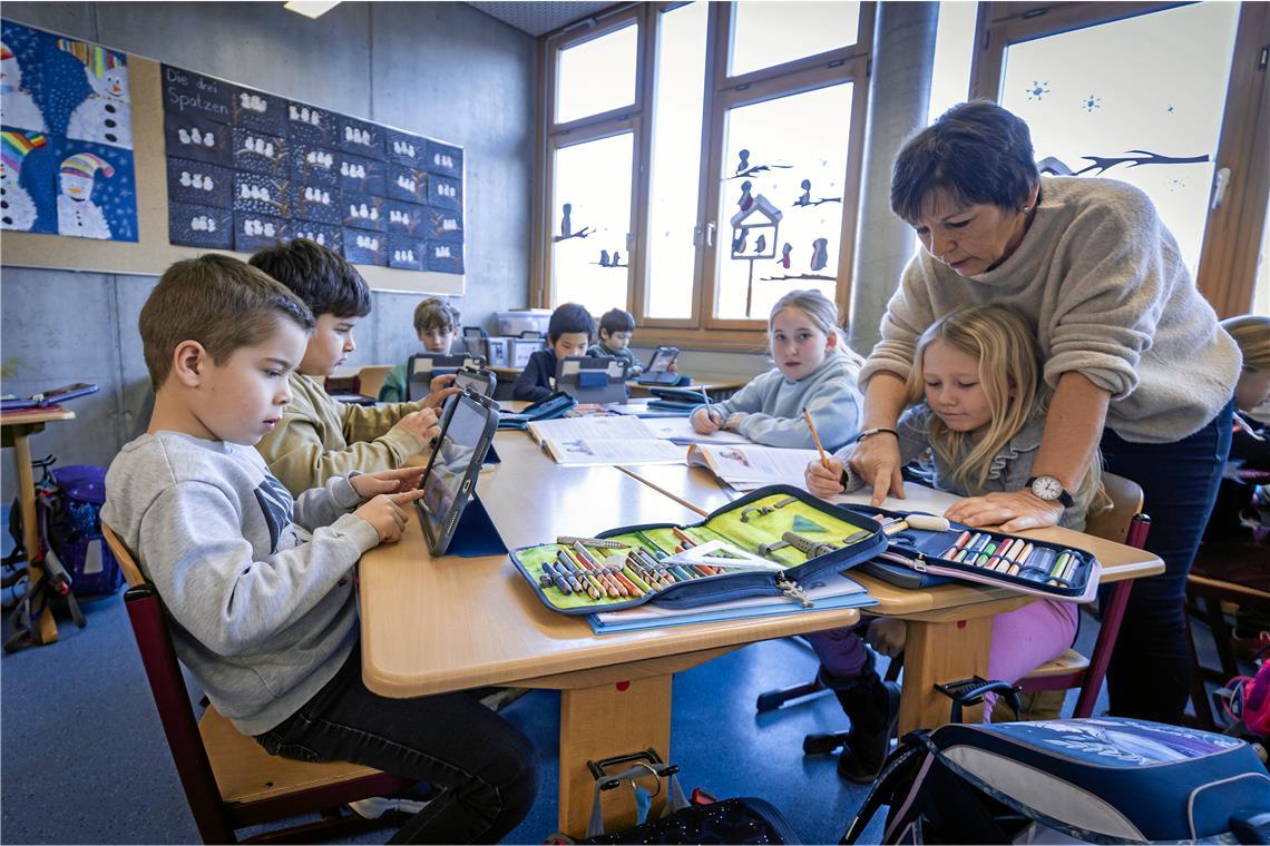 Während Lehrerin Ingrid Krämer einigen Kindern noch hilft, die Matheaufgaben im Heft zu lösen, sind andere schon damit fertig und nutzen die Zeit für weitere Übungen auf dem iPad. Fotos: Alexander Becher