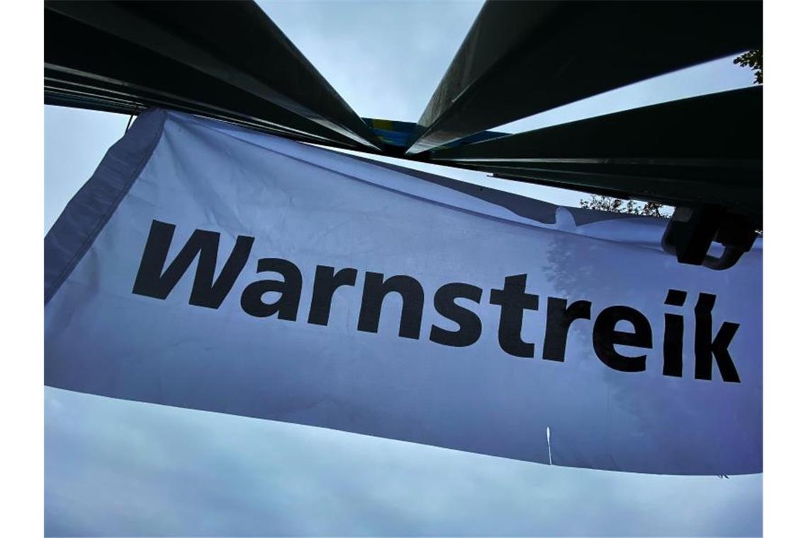 "Warnstreik" steht auf einem Transparent. Foto: Paul Zinken/dpa/Symbolbild