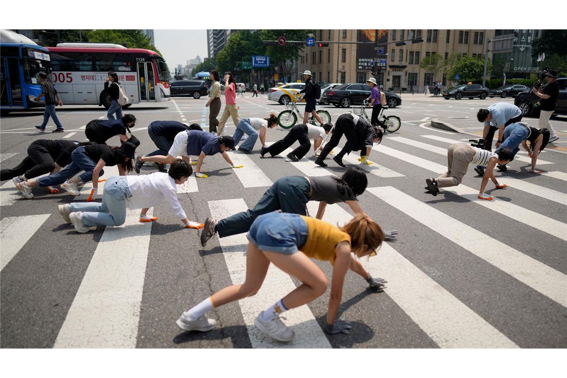 Was ist denn hier los? Einsatz für Rechte von Tieren: Mitglieder einer Umweltgruppe und Tänzer überqueren auf allen vieren eine Straße in Seoul während einer Kampagne zum Weltumwelttag.