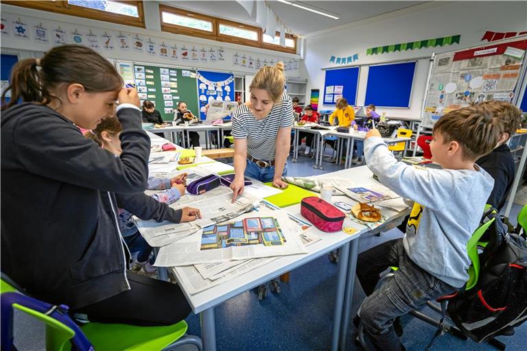 Was steht eigentlich alles in einer Zeitung? Mit ihrer Klassenlehrerin Daniela Dölker studieren die Viertklässler an der Talschule Waldrems die Backnanger Kreiszeitung und schneiden die interessantesten Überschriften aus.Foto: Alexander Becher