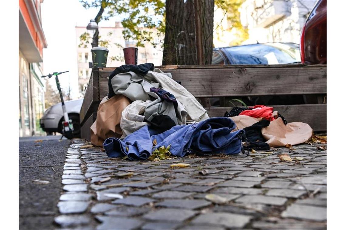 Weggeworfene Kleidung auf einem Gehweg am Straßenrand. Foto: Jens Kalaene/dpa-Zentralbild/dpa