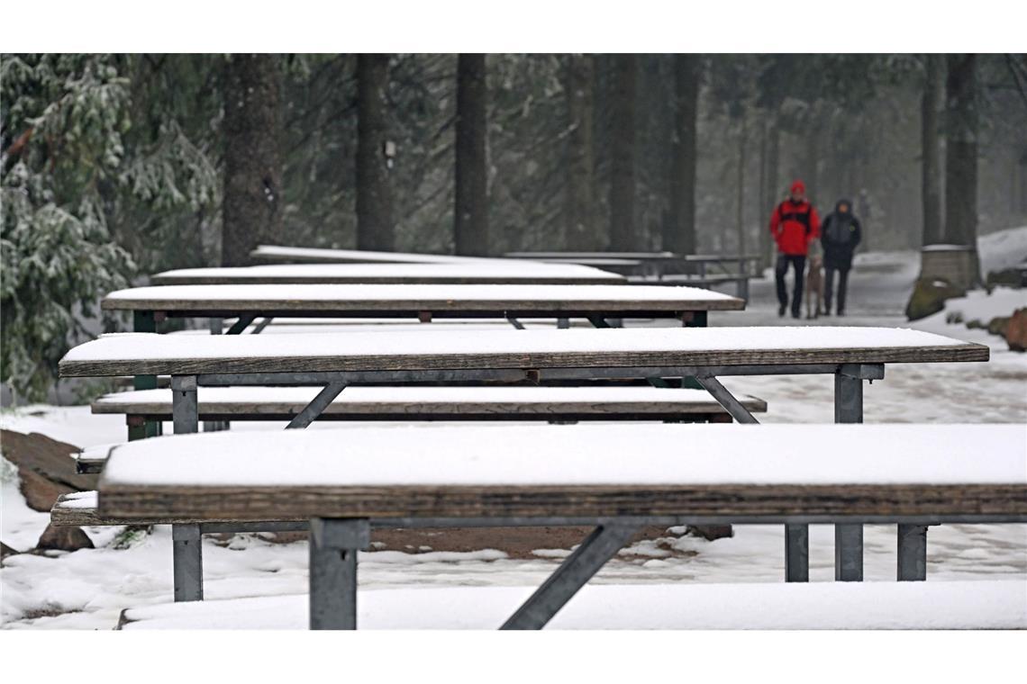 Welch ein Aprilwetter: Der Neuschnee im Schwarzwald hält diese Besucher am Mummelsee nicht davon ab, spazieren zu gehen.