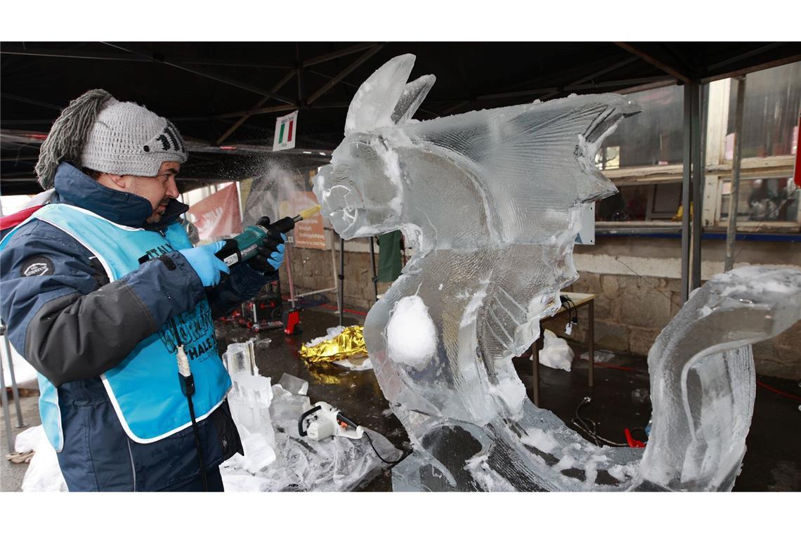 Weltcup im Eisskulpturenschnitzen: Ein Teilnehmer des Eisskulpturen Weltcup bearbeitet einen Eisblock mit einem Werkzeug.