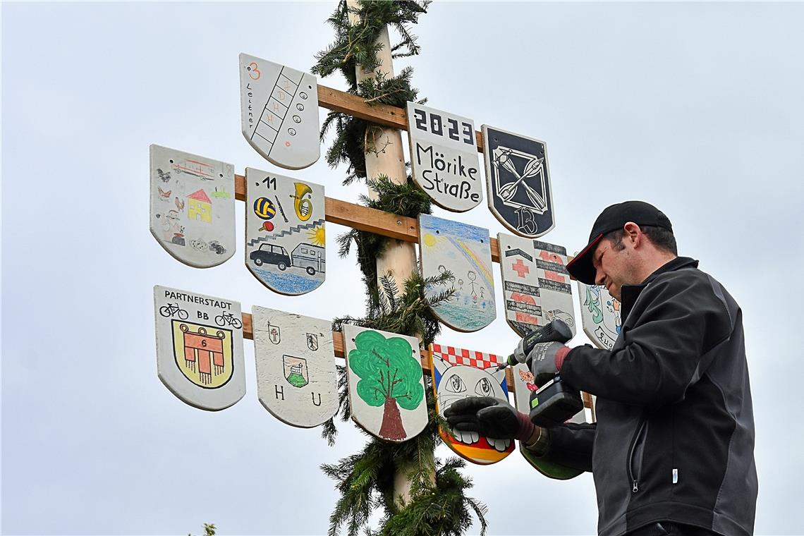 Wenn der Baum steht, werden noch die von den Familien gestalteten Wappen befestigt.