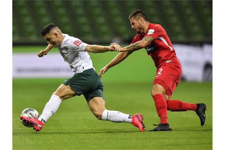 Werder-Profi Milot Rashica (l) wird vom Heidenheimer Marnon Busch verfolgt. Foto: Martin Meissner/AP POOL/dpa