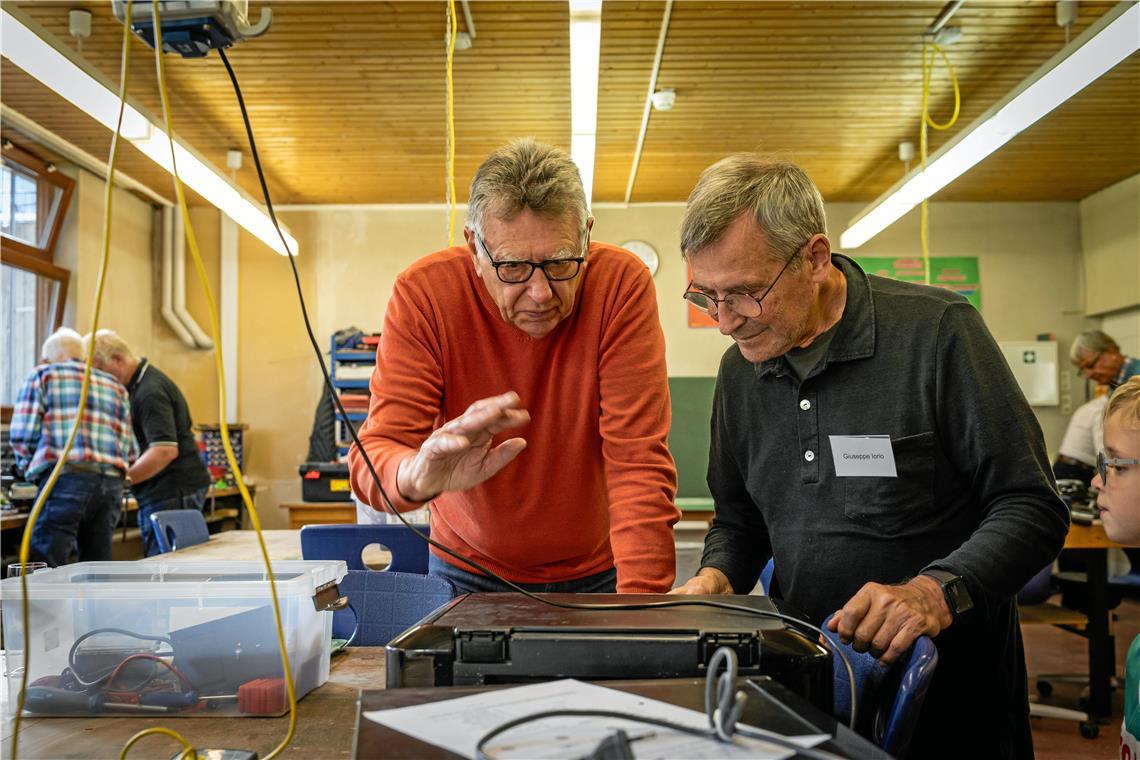 Werner Schröder (links) und Guiseppe Iorio rätseln, warum der Drucker kein Papier einzieht. Fotos: Alexander Becher