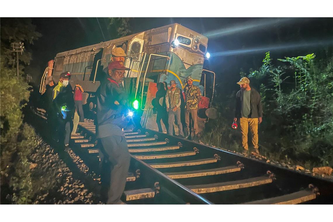 Wildhüter und Polizeibeamte stehen an einer entgleisten Lokomotive, nachdem ein Personenzug mit einer Elefantenherde zusammengestoßen ist. (Foto aktuell)