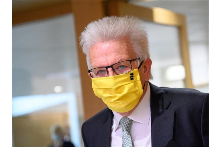 Winfried Kretschmann (Grünen), Ministerpräsident von Baden-Württemberg, kommt während einer Sitzung des Landtags mit Mundschutz. Foto: Sebastian Gollnow/dpa/Archivbild