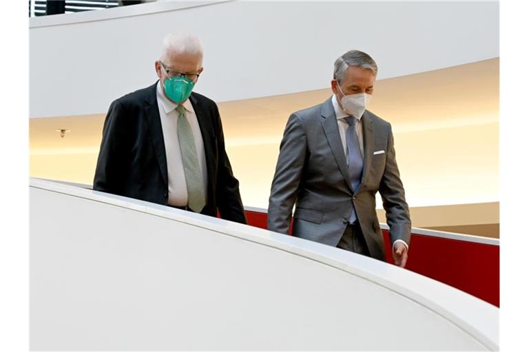 Winfried Kretschmann (l) und Martin Jetter (r, Chairmen IBM Europa) gehen zur Einweihung. Foto: Bernd Weissbrod/dpa