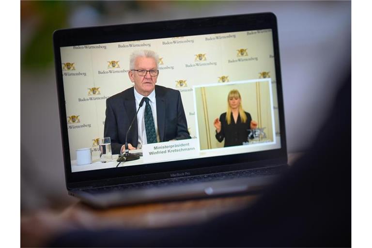 Winfried Kretschmann spricht während einer Pressekonferenz, die auf einem Laptop gestreamt wird. Foto: Sebastian Gollnow/dpa