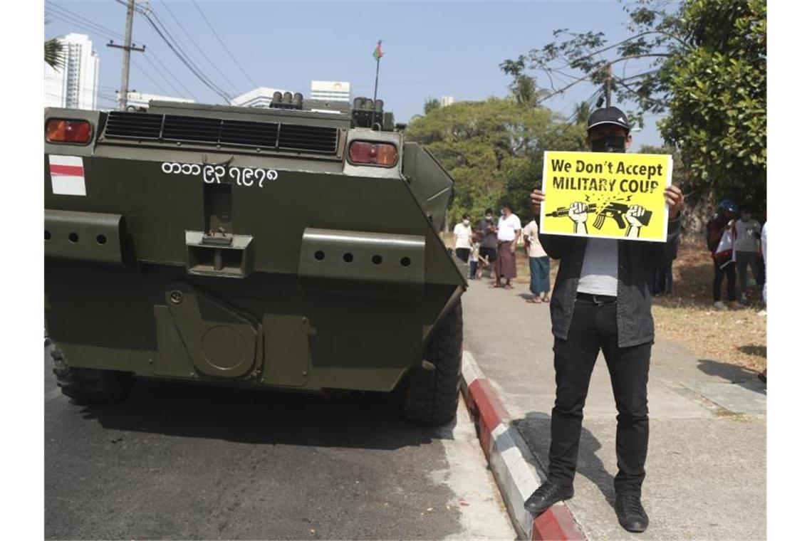 Myanmars Militär lässt die Muskeln spielen „Wir akzeptieren den Militärputsch nicht“ steht auf dem Schild, das ein Anti-Regierungsdemonstrant in Rangun hochhält. Foto: Uncredited/AP/dpa