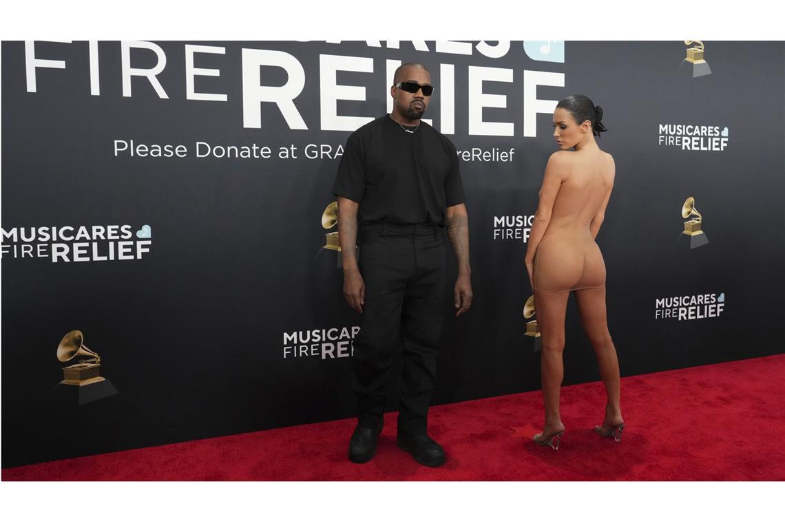 Ye alias Kanye West steht wie ein Leibwächter neben der auffällig unbekleidet wirkenden Bianca Censori bei den Grammys.