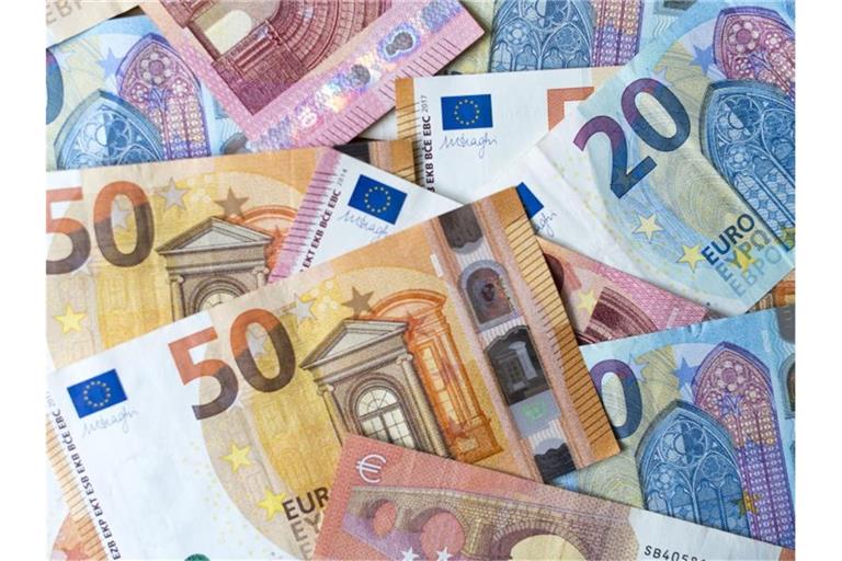 Zahlreiche Banknoten zu 10, 20 und 50 Euro liegen auf einem Tisch. Foto: Monika Skolimowska/dpa-Zentralbild/dpa/Illustration