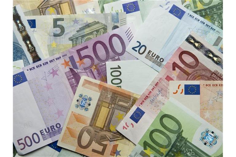 Zahlreiche Euro-Banknoten liegen auf einem Haufen. Foto: Daniel Reinhardt/dpa/Symbolbild