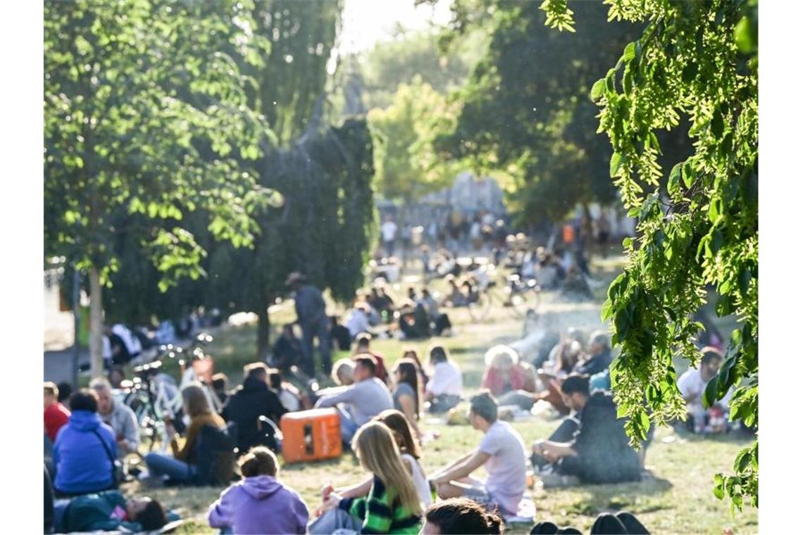 Umstrittene Entscheidung: Berliner Park macht abends zu Zahlreiche Menschen sitzen im Licht der untergehenden Sonne auf einer Wiese im James-Simon-Park. Abends und nachts soll der Besuch künftig nicht mehr erlaubt sein. Foto: Jens Kalaene/dpa-Zentralbild/dpa