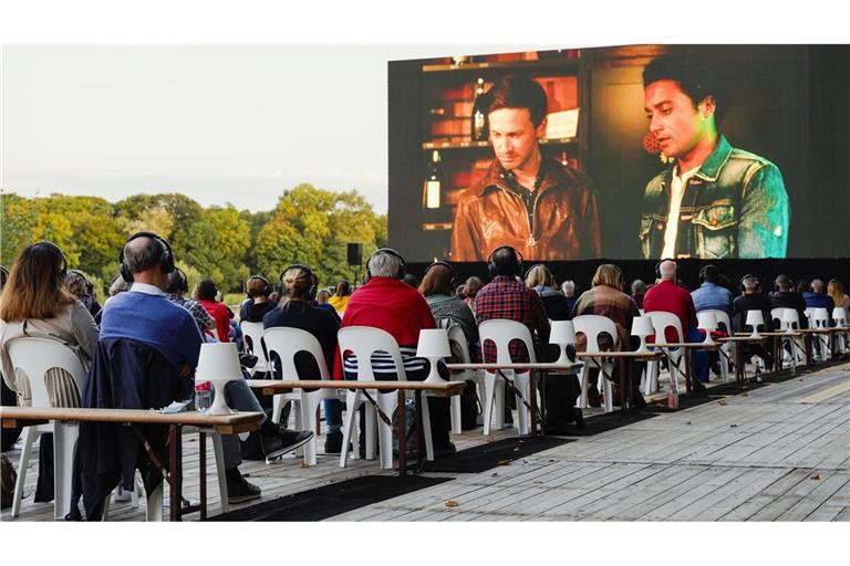 Zuschauer verfolgen beim Festival des deutschen Films auf der Parkinsel auf einer großen LED-Videoleinwand einen Kinofilm.