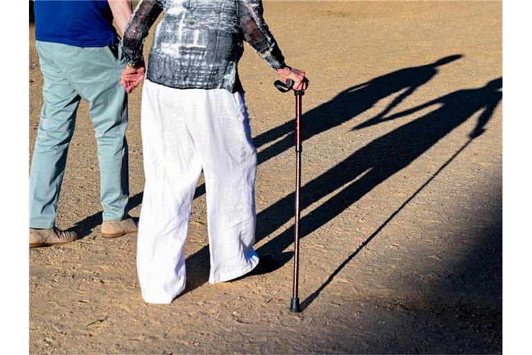 Zwei ältere Personen gehen Hand in Hand mit einem Gehstock. Foto: Patrick Pleul/dpa-Zentralbild/ZB/Symbolbild