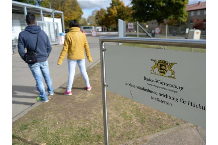 Zwei Asylbewerber warten vor dem Eingang zur Landeserstaufnahmestelle. Foto: picture alliance/dpa/Archivbild