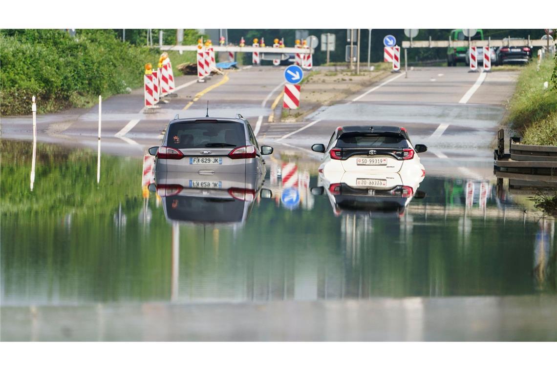Zwei Autos stehen unter einer Saarbrücke in Saarbrücken im Hochwasser.