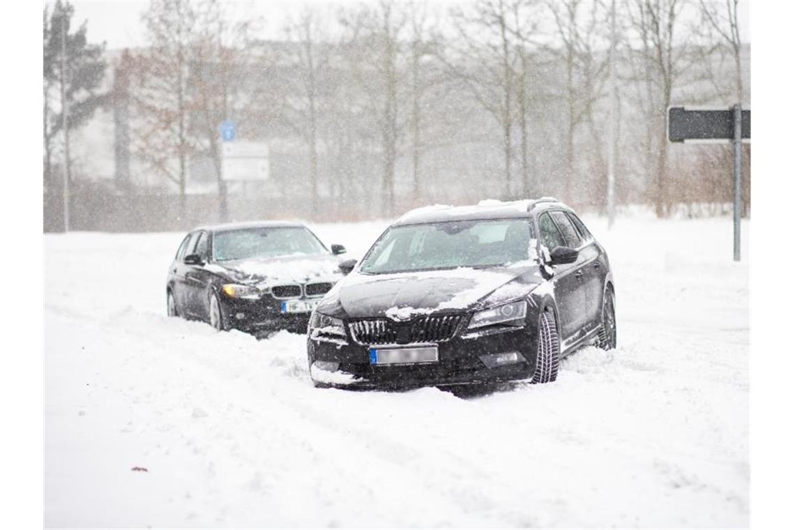 Schneesturm fegt über Deutschland - Meterhohe Verwehungen Zwei Fahrzeuge stecken auf einer Straße in Bielefeld fest. Foto: Marcel Kusch/dpa