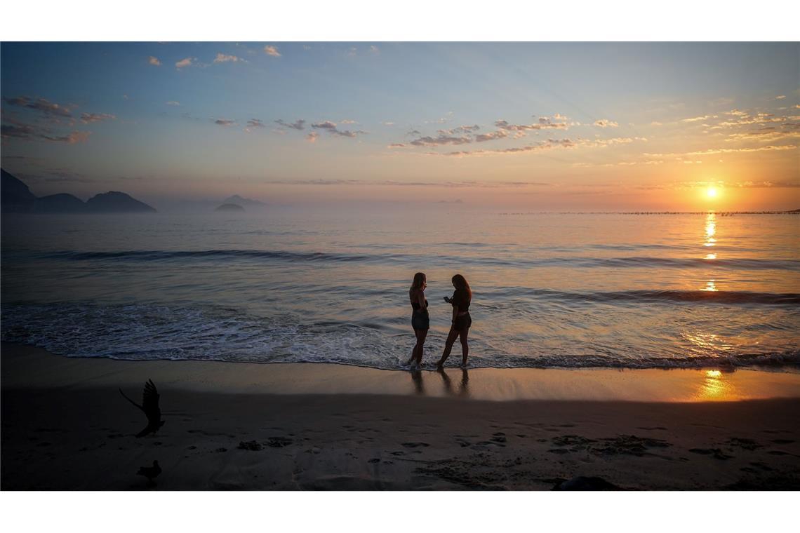 Zwei Frauen stehen am Morgen gegen fünf Uhr bei Sonnenaufgang am Strand der Copacabana in Rio. Wegen dem G20-Gipfel, der derzeit in Rio stattfindet, haben die Bürger der Stadt zwei Tage frei bekommen.