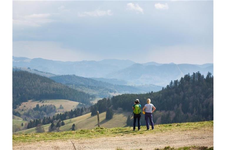 Zwei Frauen stehen auf einem Parkplatz nahe dem Nonnenmattweiher und blicken in die Landschaft. Foto: Philipp von Ditfurth/dpa/Archivbild