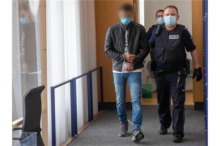 Zwei Justizwachtmeister führen im Landgericht einen Mann in den Gerichtssaal. Foto: Stefan Puchner/dpa