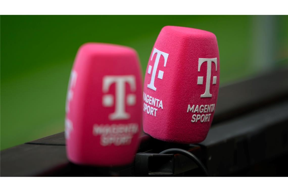 Zwei Mikrofone von Magenta Sport stecken an einer Bande bei einem Fußballplatz.