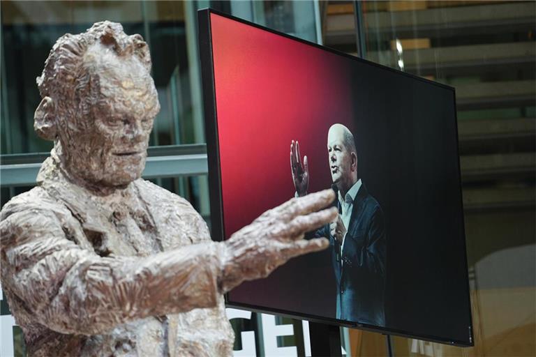 Zwei SPD-Kanzler, als Statue und auf dem Bildschirm: Willy Brandt und Olaf Scholz