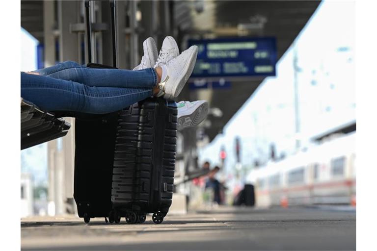 Zwei Reisegäste warten an einem Bahnhof am Gleis. Foto: Arne Dedert/dpa/Symbolbild